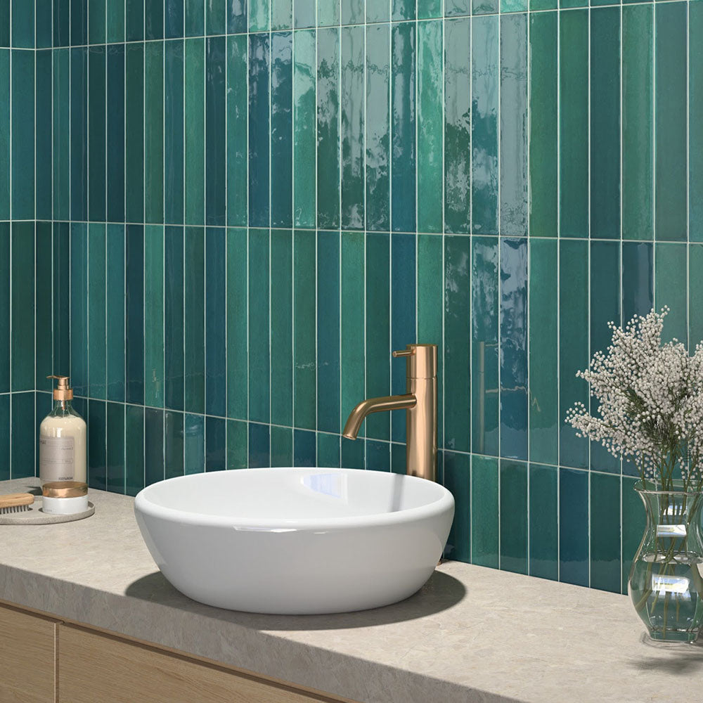 Modernes Badezimmer mit Lisbon Verde Green Wandfliesen aus Feinsteinzeug im handwerklichen Stil im Format 5 × 30 cm, vertikal verlegt, um eine lebendige Akzentwand zu schaffen. Kombiniert mit einer Waschtischplatte in Steinoptik, einer Armatur in gebürsteter Messingoptik und sanften natürlichen Materialien entsteht ein luxuriöses, spa-inspiriertes Interior.