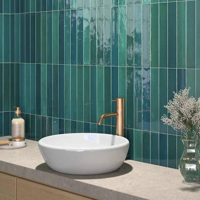 Modernes Badezimmer mit Lisbon Verde Green Wandfliesen aus Feinsteinzeug im handwerklichen Stil im Format 5 × 30 cm, vertikal verlegt, um eine lebendige Akzentwand zu schaffen. Kombiniert mit einer Waschtischplatte in Steinoptik, einer Armatur in gebürsteter Messingoptik und sanften natürlichen Materialien entsteht ein luxuriöses, spa-inspiriertes Interior.