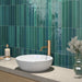 Modernes Badezimmer mit Lisbon Verde Green Wandfliesen aus Feinsteinzeug im handwerklichen Stil im Format 5 × 30 cm, vertikal verlegt, um eine lebendige Akzentwand zu schaffen. Kombiniert mit einer Waschtischplatte in Steinoptik, einer Armatur in gebürsteter Messingoptik und sanften natürlichen Materialien entsteht ein luxuriöses, spa-inspiriertes Interior.