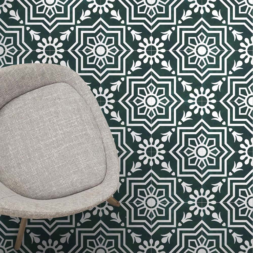 Innenraumszene mit Berlin Grün Fliesen im Format 20 × 20 cm im viktorianisch inspirierten Stil in Grün und Weiß. Markante geometrische und florale Motive werden durch einen neutral gepolsterten Stuhl kontrastreich ergänzt.