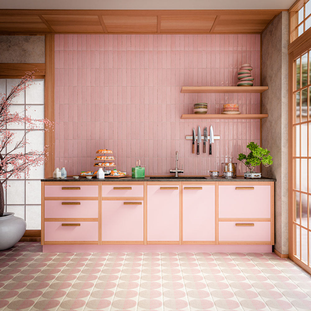 Küche mit Nomad Rose Brick Wandfliesen im Industriestil im Format 6 × 24,6 cm mit glänzender Oberfläche in zartem Rosé. Kombiniert mit passenden rosafarbenen Küchenfronten, warmen Holzregalen, schwarzen Arbeitsplatten und gemusterten Bodenfliesen entsteht ein modernes und stilvolles Küchendesign.
