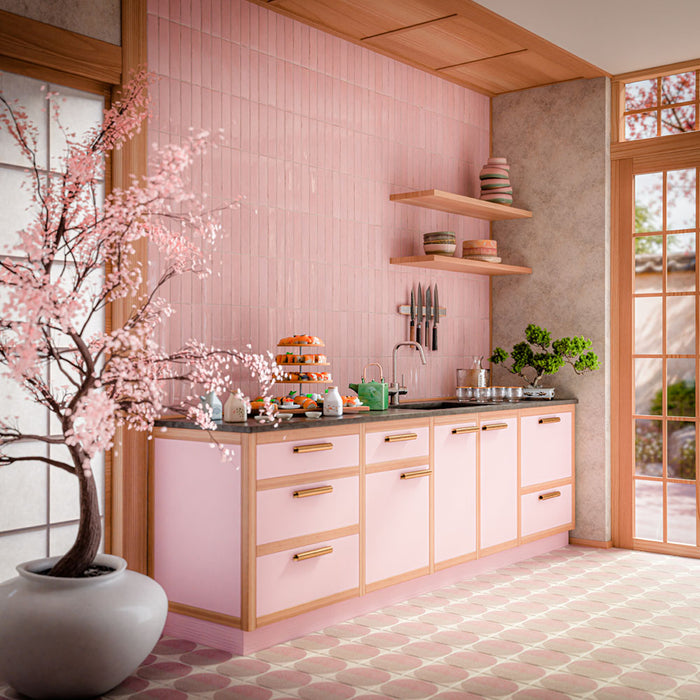 Küche mit Nomad Rose Brick Wandfliesen im Industriestil im Format 6 × 24,6 cm mit glänzender Oberfläche in zartem Rosé. Kombiniert mit passenden rosafarbenen Küchenfronten, warmen Holzregalen, schwarzen Arbeitsplatten und gemusterten Bodenfliesen entsteht ein modernes und stilvolles Küchendesign.