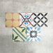 Fayrouz Patchwork Feinsteinzeugfliesen im marokkanischen Stil im Format 20 × 20 cm, angeordnet als farbenfroher Patchwork-Mix aus geometrischen und floralen Mustern. Die Gestaltung zeigt kräftige Blau-, Grün- und Rosatöne sowie warme neutrale Nuancen.
