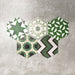 Fayrouz Verde Hexagon Patchwork Feinsteinzeugfliesen im marokkanischen Stil im Hexagonformat 18,7 × 21,6 cm, gezeigt als abgestimmter Patchwork-Mix aus geometrischen, sternförmigen und Zickzack-Mustern. Die Anordnung in verschiedenen Grün-, Salbei-, Mint- und Anthrazittönen hebt die Farbvielfalt und die abwechslungsreiche Musterstruktur dekorativ hervor.