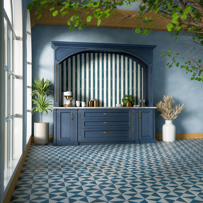 Kücheninterieur mit glänzenden Elazar Blue Ziegelfliesen im Format 6 × 25 cm, vertikal in einer Nische als Statement verlegt. Die satten Blautöne mit reflektierender Glasur sorgen für eine ausdrucksstarke Wirkung und werden durch tiefblaue Schränke, Messingakzente und eine Arbeitsplatte in Marmoroptik ergänzt – für ein zugleich markantes und elegantes Design.