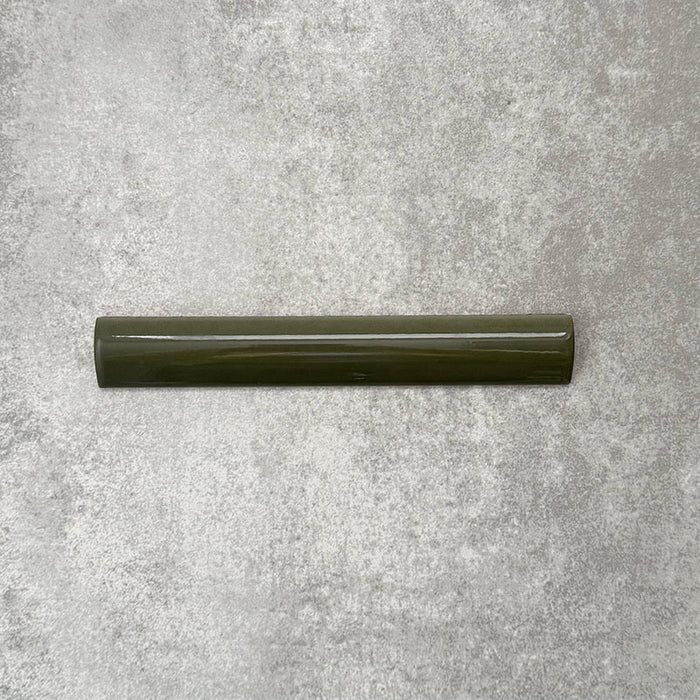 Zellige Botanisches Grün Bordürenfliese Keramik-Abschlussfliese im marokkanischen Stil im Format 3 × 20 cm, in satten botanischen Grüntönen. Mit weich gerundeter Kante und glänzender Glasur auf einem strukturierten grauen Hintergrund präsentiert, um den handwerklichen Zellige-Effekt und das dekorative Randprofil zu zeigen.