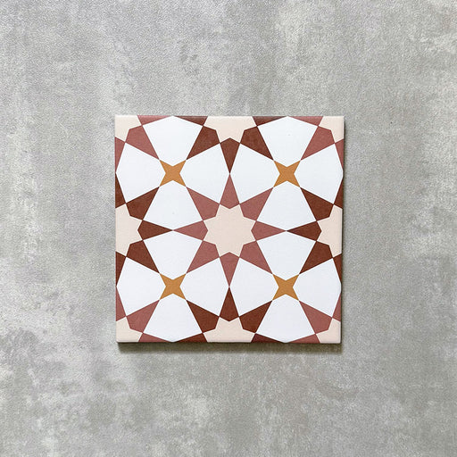 Einzelne Agadir Terrakotta Fliese im marokkanischen Stil im Format 20 × 20 cm aus Feinsteinzeug mit einem geometrischen Sternmuster in warmen Terrakotta-, Weiß- und sanften Gelbtönen, dargestellt auf neutralem Hintergrund.