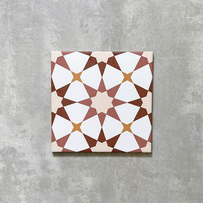 Einzelne Agadir Terrakotta Fliese im marokkanischen Stil im Format 20 × 20 cm aus Feinsteinzeug mit einem geometrischen Sternmuster in warmen Terrakotta-, Weiß- und sanften Gelbtönen, dargestellt auf neutralem Hintergrund.