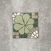 Einzelne Kuba Laurent Nantes Fliese im marokkanischen Stil im Format 20 × 20 cm mit floral inspiriertem Motiv in sanften Grüntönen sowie Mosaik-Details in dezenten Neutral- und Weißtönen. Eine dekorative Musterfliese, ideal für Akzentwände, Böden oder ausdrucksstarke Küchenrückwände.