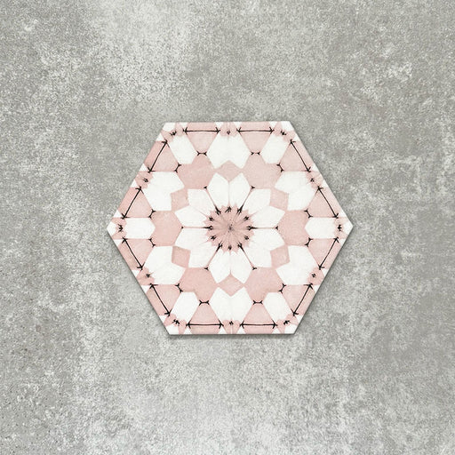 Einzelne Medina Rosa Feinsteinzeug-Hexagonfliese im marokkanischen Stil im Format 18,7 × 21,6 cm, mit einem feinen geometrischen Muster in pudrigem Rosa und Weiß, gezeigt vor neutralem Hintergrund.
