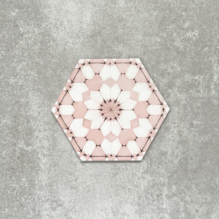 Einzelne Medina Rosa Feinsteinzeug-Hexagonfliese im marokkanischen Stil im Format 18,7 × 21,6 cm, mit einem feinen geometrischen Muster in pudrigem Rosa und Weiß, gezeigt vor neutralem Hintergrund.