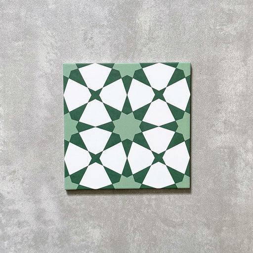 Einzelne Agadir Grün Fliese im marokkanischen Stil im Format 20 × 20 cm aus Feinsteinzeug mit einem geometrischen Sternmuster in sanftem Grün und Weiß, dargestellt auf neutralem Hintergrund.