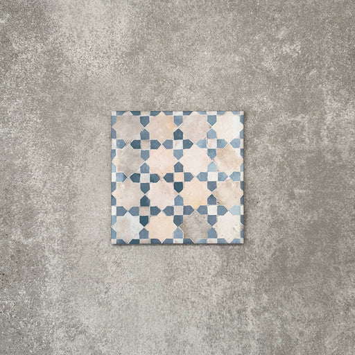 Einzelne Berber Mequinez Blau Feinsteinzeugfliese im marokkanischen Stil im Format 15 × 15 cm mit einem geometrischen Muster in Blau und Creme, dargestellt auf neutralem Hintergrund.