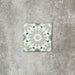 Single Fez Mini Jade Green 15x15cm Moroccan-style porcelain tile displayed against a textured grey background, highlighting the soft jade green and white geometric star pattern with an encaustic-inspired finish.