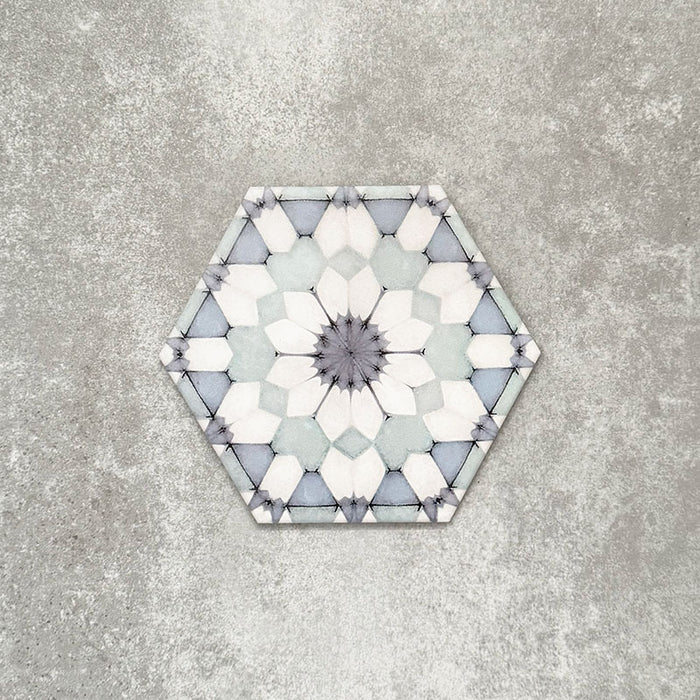 Einzelne Medina Frostblau Feinsteinzeug-Hexagonfliese im marokkanischen Stil im Format 18,7 × 21,6 cm, mit einem feinen geometrischen Muster in sanften Blau- und Weißtönen, gezeigt vor neutralem Hintergrund.