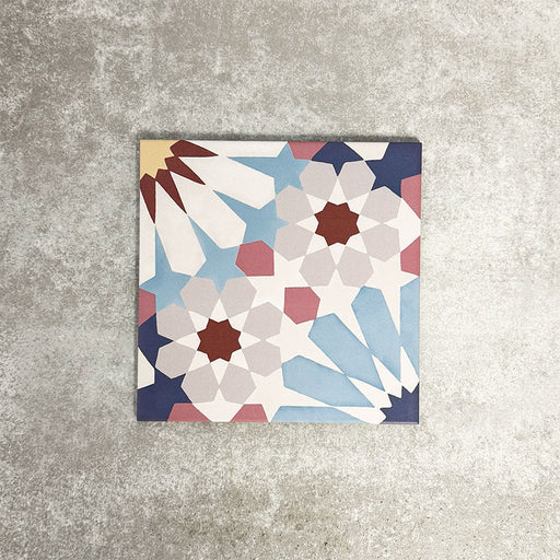 Fez Fiera Moroccan style porcelain tile with a geometric star pattern in blue, terracotta, grey and cream, shown as a single 20cm x 20cm tile