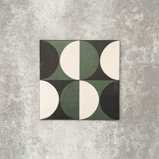 Einzelne Abstrakte Kreise Musterfliese im Format 20 × 20 cm mit einem markanten geometrischen Design aus abwechselnden Kreissegmenten in tiefem Grün, Anthrazit und sanften Cremetönen. Eine moderne Musterfliese, ideal für Akzentwände, Bodenflächen oder ausdrucksstarke Küchenrückwände.