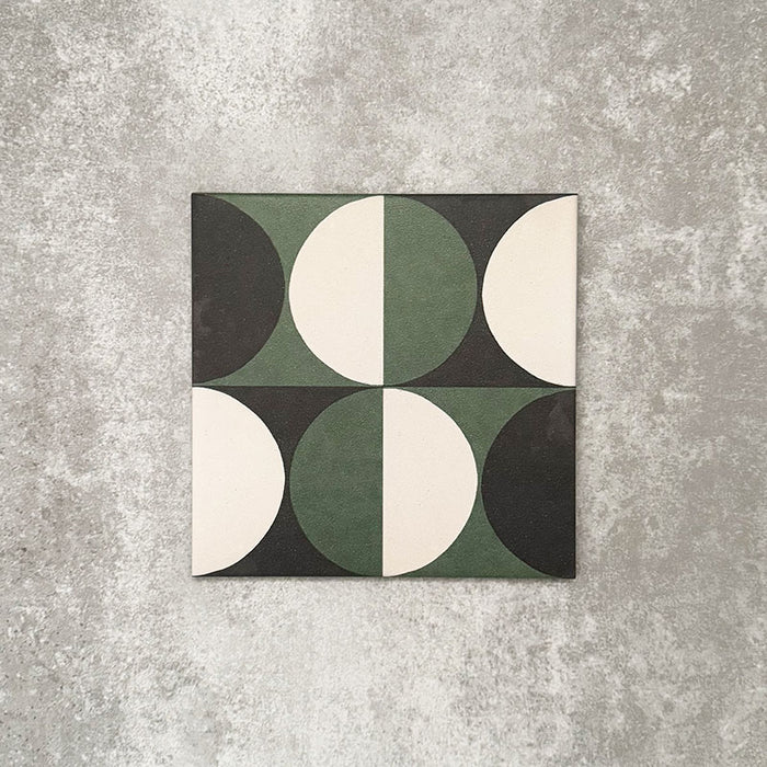Einzelne Abstrakte Kreise Musterfliese im Format 20 × 20 cm mit einem markanten geometrischen Design aus abwechselnden Kreissegmenten in tiefem Grün, Anthrazit und sanften Cremetönen. Eine moderne Musterfliese, ideal für Akzentwände, Bodenflächen oder ausdrucksstarke Küchenrückwände.