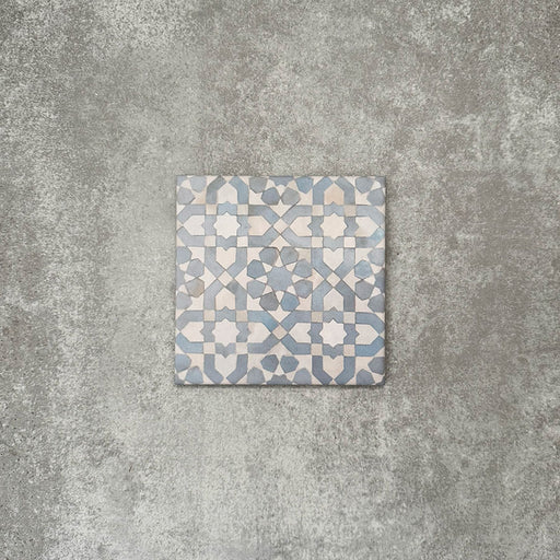 Einzelne Berber Tetuan Blau Feinsteinzeugfliese im marokkanischen Stil im Format 15 × 15 cm mit einem sanften geometrischen Muster in Blau und Creme, dargestellt auf neutralem Hintergrund.