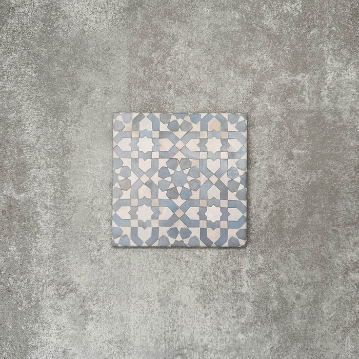 Einzelne Berber Tetuan Blau Feinsteinzeugfliese im marokkanischen Stil im Format 15 × 15 cm mit einem sanften geometrischen Muster in Blau und Creme, dargestellt auf neutralem Hintergrund.