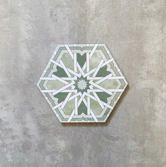 Einzelne Medina Hormuz Grün Feinsteinzeug-Hexagonfliese im marokkanischen Stil im Format 18,7 × 21,6 cm, mit einem markanten, sterninspirierten geometrischen Muster in Grün- und Weißtönen, gezeigt vor neutralem Hintergrund.