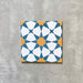 Einzelne Agadir Blau & Gelb Fliese im marokkanischen Stil im Format 20 × 20 cm aus Feinsteinzeug mit geometrischem Sternmuster in Blau, Weiß und warmem Gelb, dargestellt auf neutralem Hintergrund.