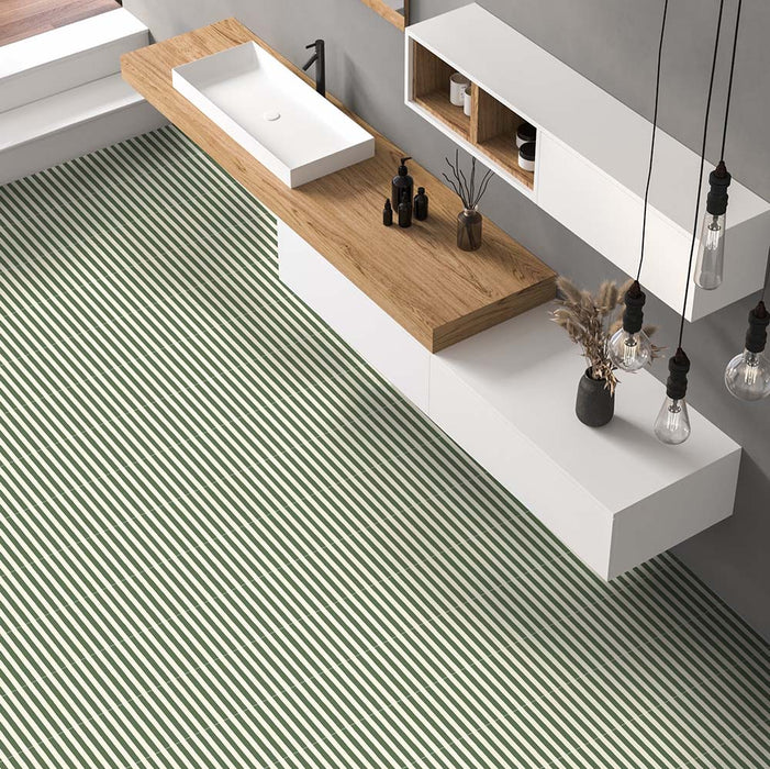 Modernes Badezimmer mit Skinny Pinstripes Green Bodenfliesen im Moroccan Style im Format 20 × 20 cm, die ein markantes Streifendesign auf dem Boden schaffen. Kombiniert mit Möbeln in Holzoptik, schwebenden Stauraumelementen und minimalistischen schwarzen Armaturen entsteht ein modernes Interior mit charakterstarker Ausstrahlung.