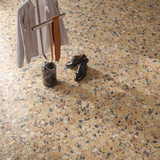 Overhead view of the Stuzzi Amber 60x120cm terrazzo style porcelain floor tiles, showcasing a warm amber base with multicoloured stone fragments in cream, ochre, rust, charcoal and grey. The realistic 4D brushed finish adds texture and depth, creating a striking terrazzo effect in a contemporary interior.