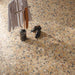 Overhead view of the Stuzzi Amber 60x120cm terrazzo style porcelain floor tiles, showcasing a warm amber base with multicoloured stone fragments in cream, ochre, rust, charcoal and grey. The realistic 4D brushed finish adds texture and depth, creating a striking terrazzo effect in a contemporary interior.