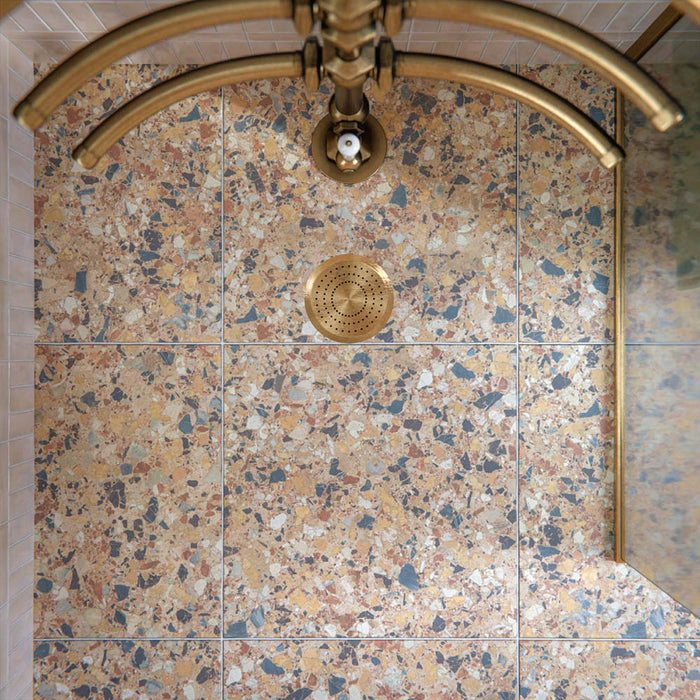 Luxury bathroom featuring Stuzzi Amber 60x60cm classical terrazzo style porcelain floor tiles with a 4D brushed finish, paired with soft blush gloss wall tiles, a sage green vanity unit, pink basins, brushed brass fittings and vintage-inspired details.