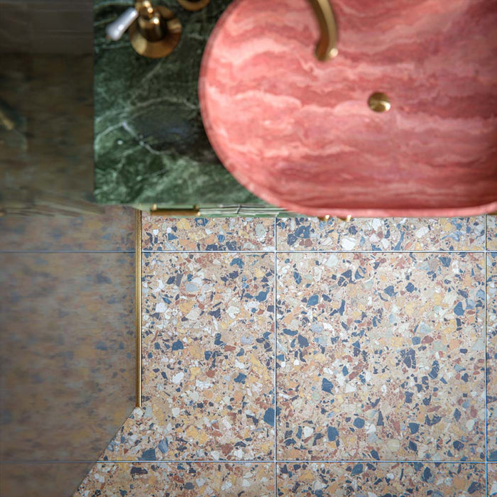 Luxury bathroom featuring Stuzzi Amber 60x60cm classical terrazzo style porcelain floor tiles with a 4D brushed finish, paired with soft blush gloss wall tiles, a sage green vanity unit, pink basins, brushed brass fittings and vintage-inspired details.