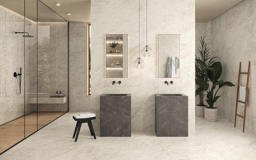 Contemporary bathroom featuring Taj Mahal Matt 60 × 120cm marble effect porcelain wall and floor tiles, showcasing soft cream tones with subtle, flowing veining. Paired with dark stone basins, black fittings, and warm wood accents, the space feels calm, balanced, and quietly luxurious.