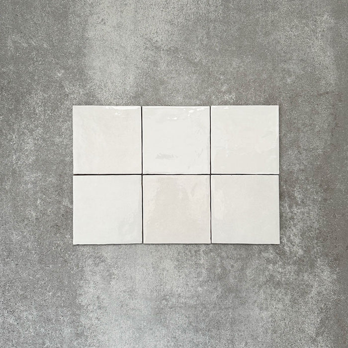 Zellige Weiß Quadrat Fliesen, im schlichten Raster verlegt, mit glänzend weißem Finish, dezenter tonaler Variation und sanft unregelmäßigen Kanten.