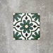 Einzelne Clara Grün Feinsteinzeugfliese im viktorianisch-marokkanischen Stil im Format 20 × 20 cm, dargestellt zur Hervorhebung des markanten grünen geometrischen Musters und des dekorativen Zementfliesen-Effekts.