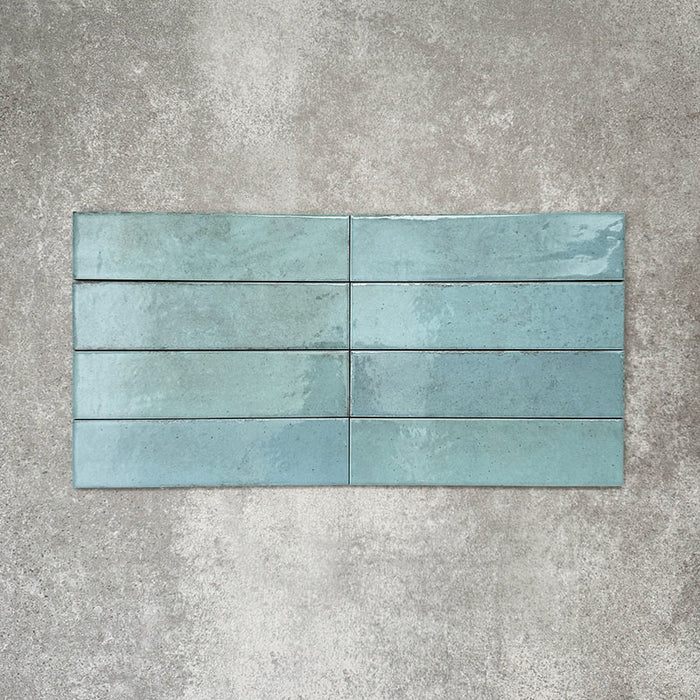 Nomadin Aqua Ziegel-Wandfliesen im Format 6 × 24,6 cm, vertikal verlegt, mit glänzender, leicht strukturierter Oberfläche und sanften Blau-Grün-Tönen für eine industrielle Anmutung.