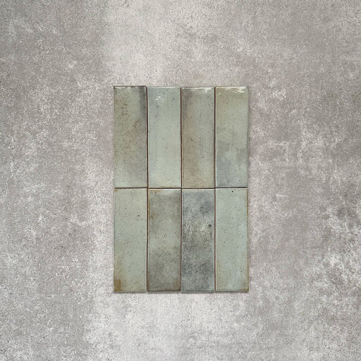 Detailaufnahme der Saigon Seladongrün Brick Wandfliesen im marokkanischen Stil. Glänzende Keramikfliesen im Format 5,1 × 16,1 cm mit sanften Grün- und Blautonvariationen, vertikal verlegt.