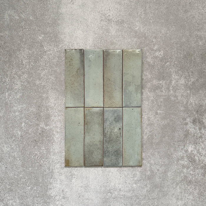 Detailaufnahme der Saigon Seladongrün Brick Wandfliesen im marokkanischen Stil. Glänzende Keramikfliesen im Format 5,1 × 16,1 cm mit sanften Grün- und Blautonvariationen, vertikal verlegt.