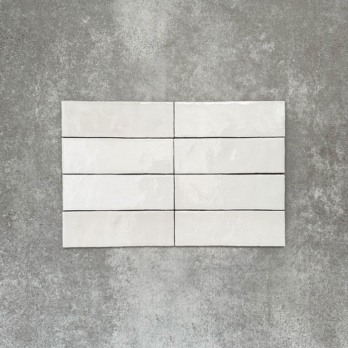 Zellige Weiß Ziegel Fliesen im Format 6,5 × 20 cm, gezeigt in klarem Weiß mit glänzender Oberfläche und feiner Oberflächenvariation.