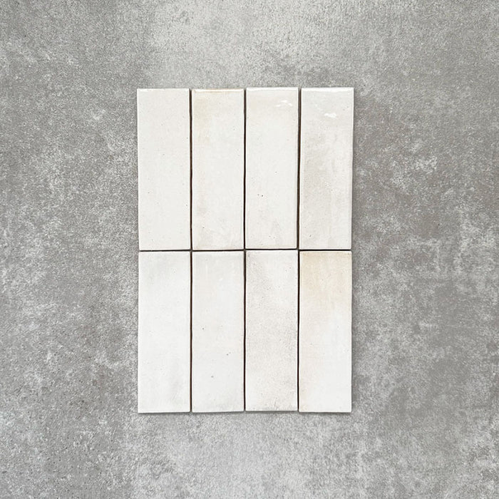 Detailaufnahme der Saigon Weiß Brick Wandfliesen im marokkanischen Stil. Glänzende Keramikfliesen im Format 5,1 × 16,1 cm in sanften Weißtönen mit feiner tonaler Variation, vertikal verlegt.