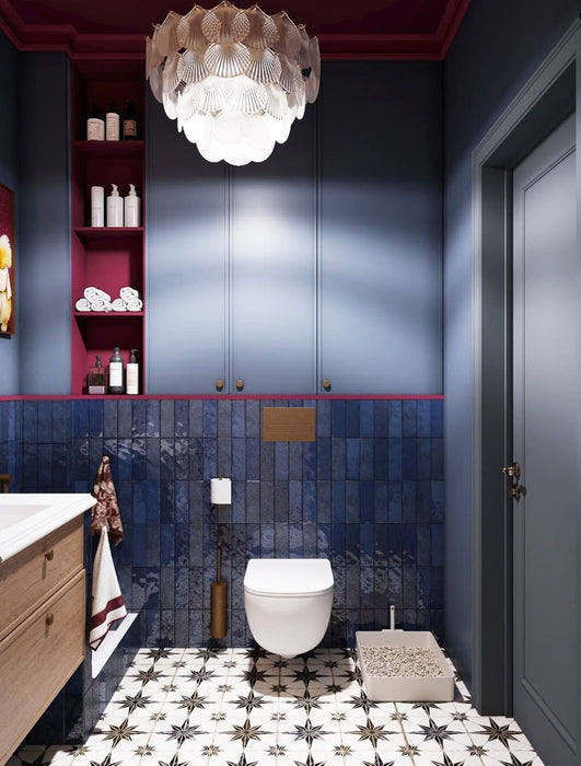 Badezimmer mit vertikal verlegten Zellige Königliches Blau Ziegel Wandfliesen im Format 6,5 × 20 cm im marokkanischen Stil, kombiniert mit gemusterten Bodenfliesen, dunkelblauen Wänden, burgunderroten Akzenten und einem Waschtischunterschrank aus Holz.