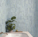 Badezimmer mit Zellige Sky Blue Matt Brick-Wandfliesen im Format 6,5 × 20 cm im Moroccan Style, in sanften Himmelblautönen mit dezenten Farbvariationen und matter Oberfläche. Die Fliesen schaffen eine beruhigende Kulisse rund um eine moderne Badewanne und werden durch warme Armaturen in Messingoptik sowie natürliche Pflanzen ergänzt.